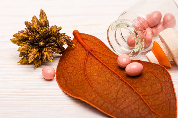 Alternative pink pills with orange leaf stock photo