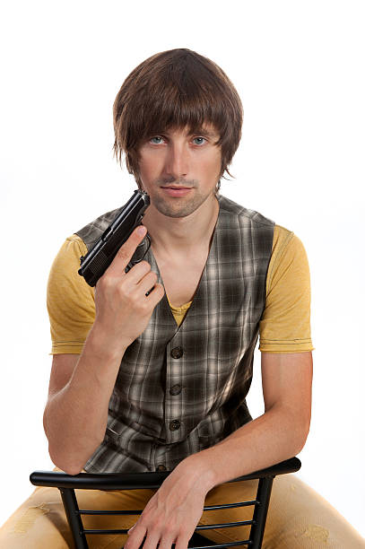 istock young man with a gun in his hand 615103032