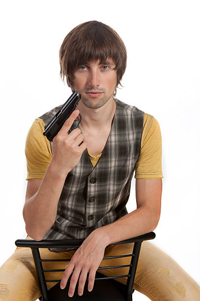 istock young man with a gun in his hand 615103098