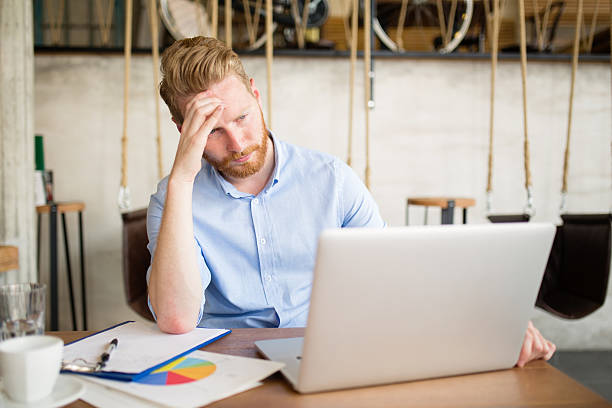 istock Young overworked businessman using laptop during coffee break. 615106200