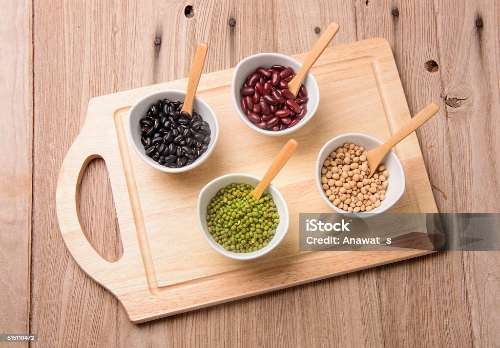 four colored beans  in ceramic bowl on wood block Agriculture Stock Photo