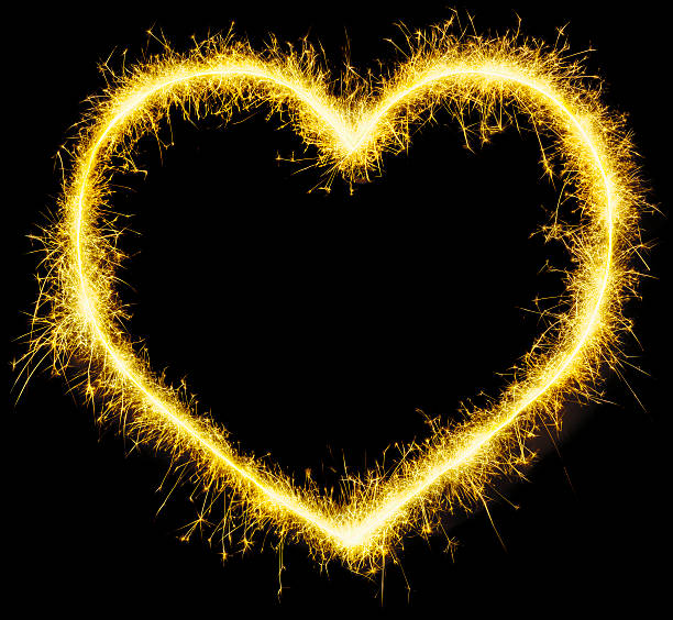 istock Golden sparklers glowing heart on black 615111804