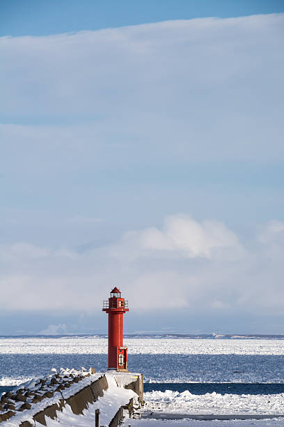 istock Red lighthouse of the winter port 615115048