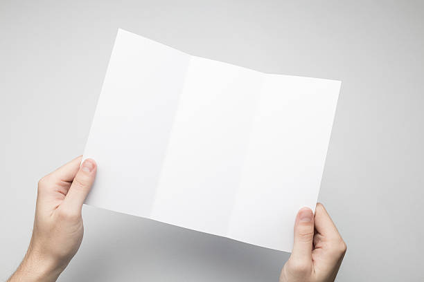 istock Hands are holding a Dl Tri-Fold white paper poster. 615115868