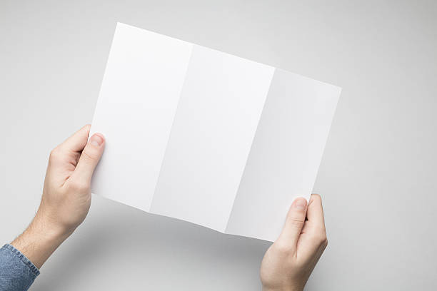 istock Hands are holding a Dl Tri-Fold white paper poster. 615115902