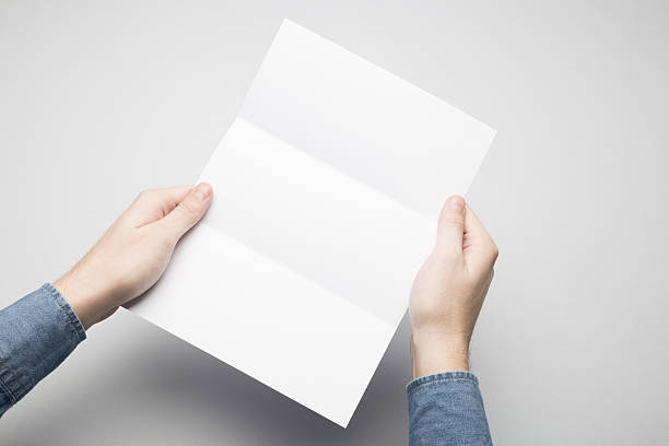 istock Hands are holding a Dl Tri-Fold white paper poster. 615115962