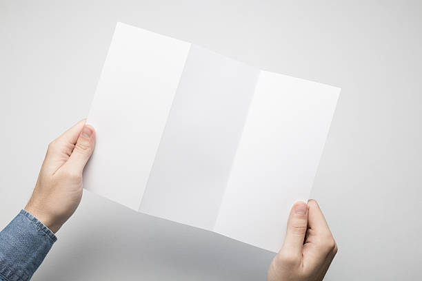 istock Hands are holding a Dl Z-Fold white paper poster. 615116056