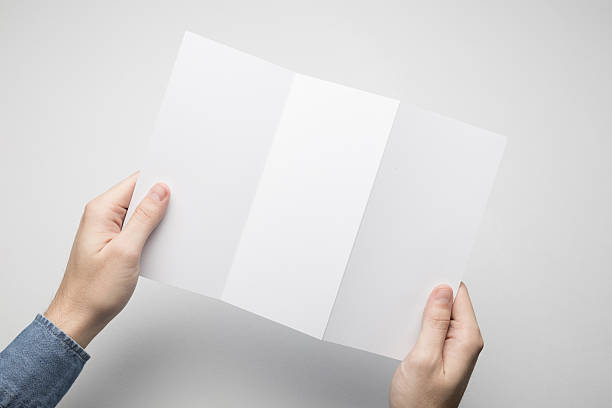 istock Hands are holding a Dl Z-Fold white paper poster. 615116110