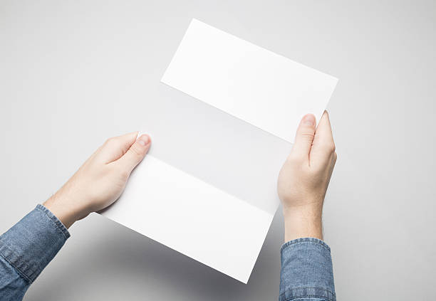 istock Hands are holding a Dl Z-Fold white paper poster. 615116164