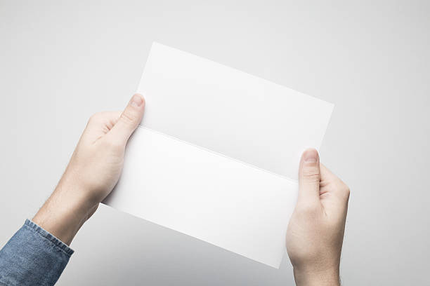 istock Hands are holding a Dl Bi-Fold white paper poster. 615116520