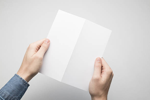 istock Hands are holding a Dl Bi-Fold white paper poster. 615116572