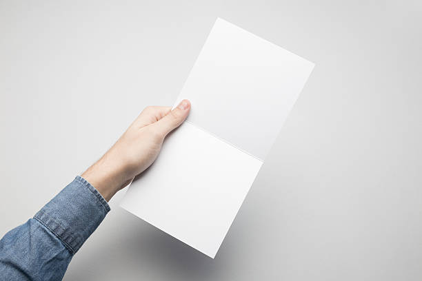 istock Hands are holding a Square Bi-Fold white paper poster. 615116740
