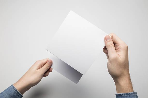 istock Hands are holding a Square Z-Fold white paper poster. 615116824