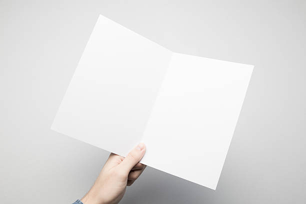 istock Hands are holding a A5 Bi-Fold white paper poster. 615116944