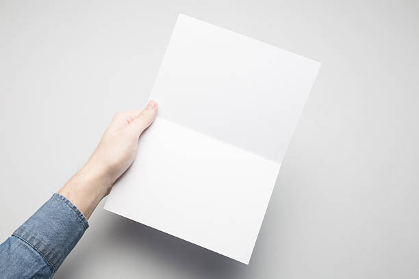 istock Hands are holding a A5 Bi-Fold white paper poster. 615117058