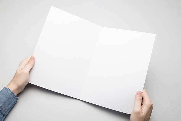 istock Hands are holding a A4 Bi-Fold white paper poster. 615117102