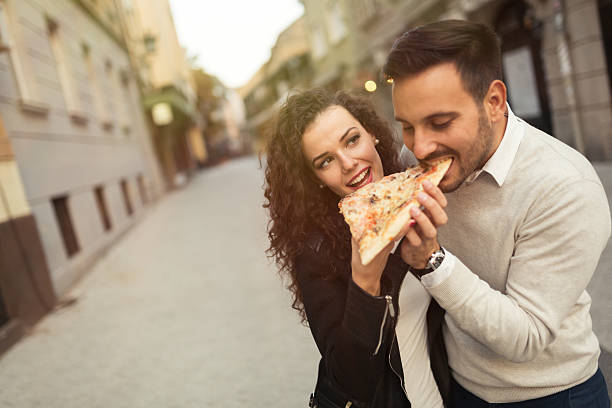 istock Couple eating pizza outdoors 615117866