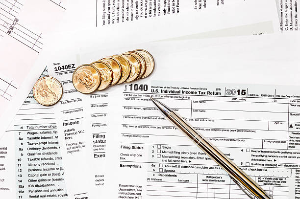istock Pen and coins on the tax form 615118080
