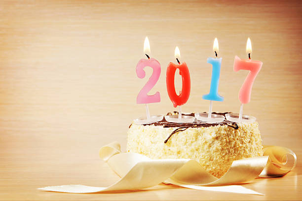istock New Year 2017 composition. Cake and burning candles 615232714