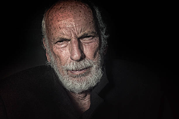 istock Senior Man with Puzzled, Questioning Look Against Black Background 615233358