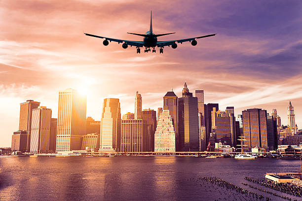 An Airplane approaching New York at sunset stock photo