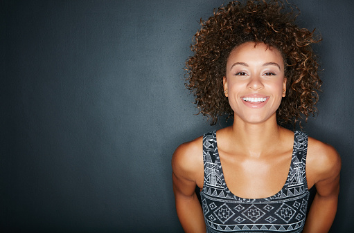 Studio shot of a happy woman posing against a dark background