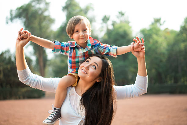 istock Young mother carrying son and looking up 615238820