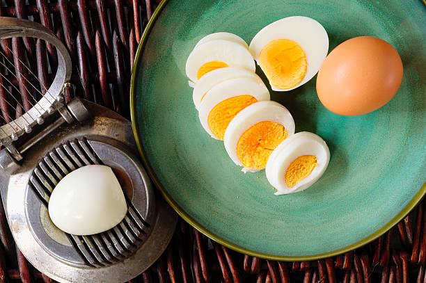 Hard-boiled egg cut and piled on egg slicer stock photo