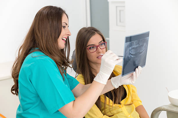 dentista femenina que muestra su radiografía de rayos x paciente - x ray image radiologist examining using voice fotografías e imágenes de stock