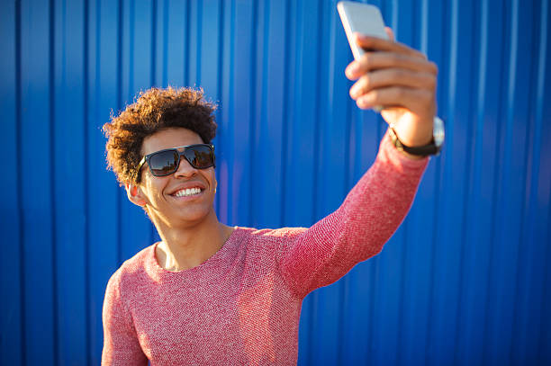 istock happy african guy smiling and taking a selfie photo 615245274