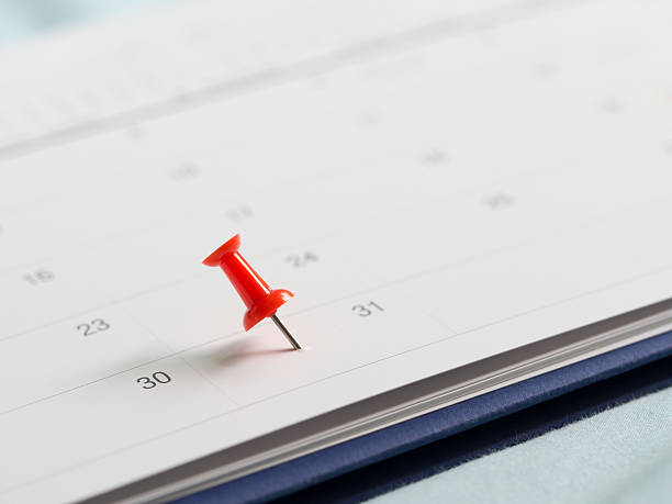 31日の終わりの月の白いカレンダーに赤いピンプッシュ。 - calendar deadline personal organizer thumbtack ストックフォトと画像