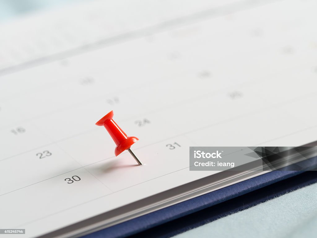 Red pin push on day 31 end month white calendar. Red pin push on day 31 of end month on white calendar. Mark this day as salary date. Concept of meeting appointment reminder. Calendar Stock Photo