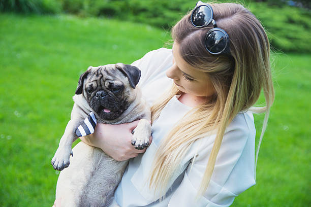 istock Young woman loving and holding her pug 615249998