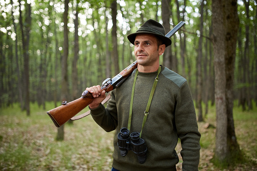 Hunter with double barrel shotgun in the forest