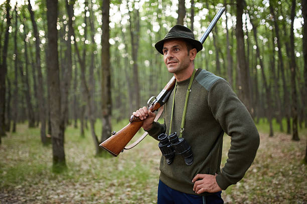 chasseur au fusil de chasse dans la forêt - employé de domaine photos et images de collection