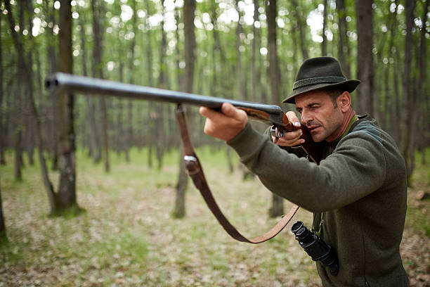 istock Hunter with shotgun in the forest 615257136