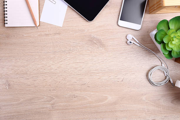 istock smartphone, tablet and office supplies on wooden background 615257322