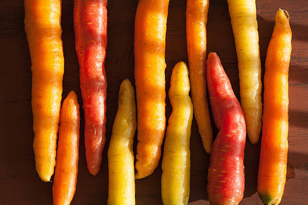 istock raw colorful carrot vegetable on wooden background 615257520