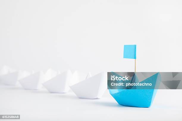 Leadership Concept With Blue Paper Ship Leading Among White Stock Photo - Download Image Now