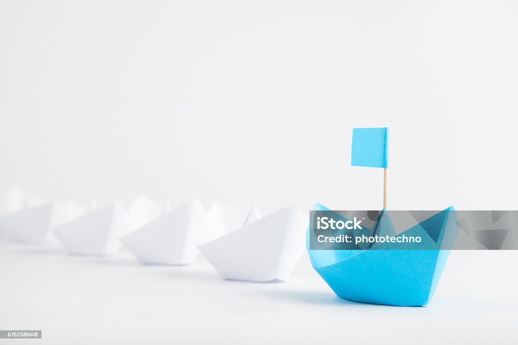 Conceito de liderança com navio de papel azul liderando entre brancos - Foto de stock de Liderança royalty-free