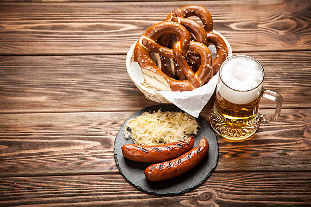 나무 테이블에 프레첼, 브래트부르스트, 소금에 절인 양배추 - pretzel german culture food salt 뉴스 사진 이미지