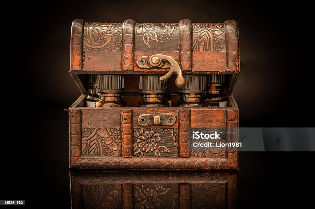 Potions in a box Bottles of tincture or potion in a retro styled old treasure chest on black background Potion Stock Photo