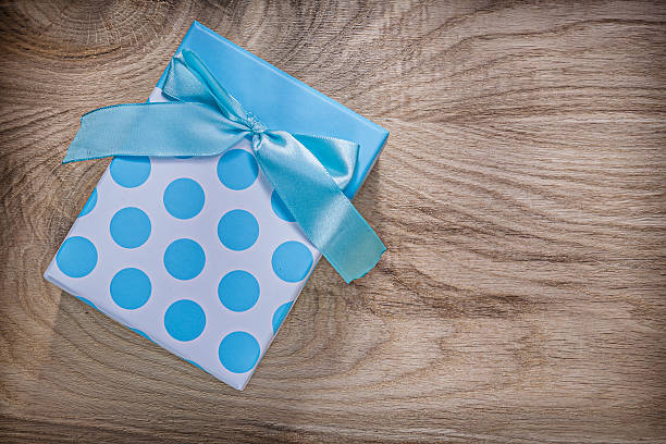 istock Blue present box with bow on wooden board celebrations concept 615265476