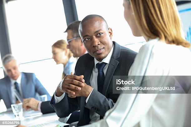 Young Businessman Discussing With Female Colleague In Meeting Room Stock Photo - Download Image Now
