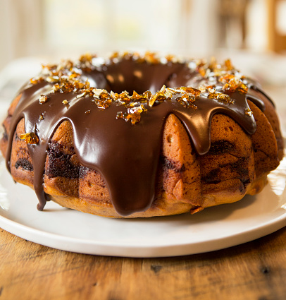 Pumpkin spice bundt cake with chocolate ganache frosting and pumpkin seed brittle.