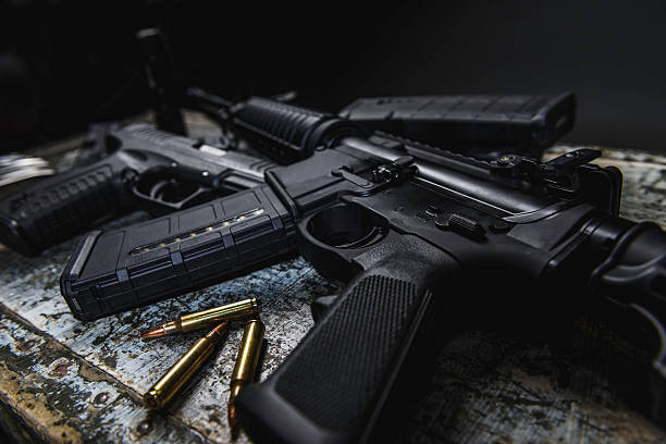 AR 15 AR 15 with ammunition laying near it. gun control photos stock pictures, royalty-free photos & images