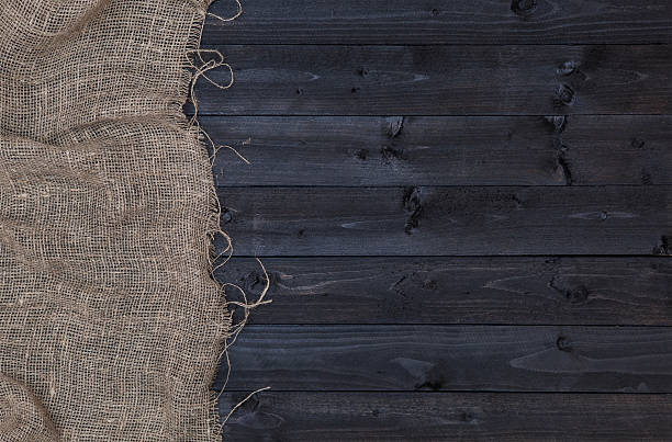 istock Burlap hessian or sacking on dark wooden background 615270548