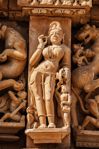 Stone carving bas relief sculpture of woman on Adinath Temple, Khajuraho, Madhya Pradesh, India