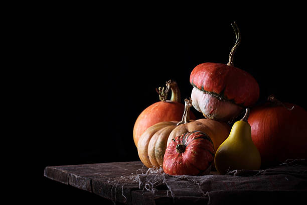 istock Pumpkins on wooden table in dark background 615271226