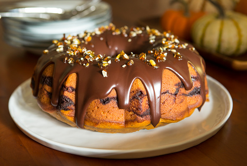 Pumpkin spice bundt cake with chocolate ganache and pumpkin seed brittle.